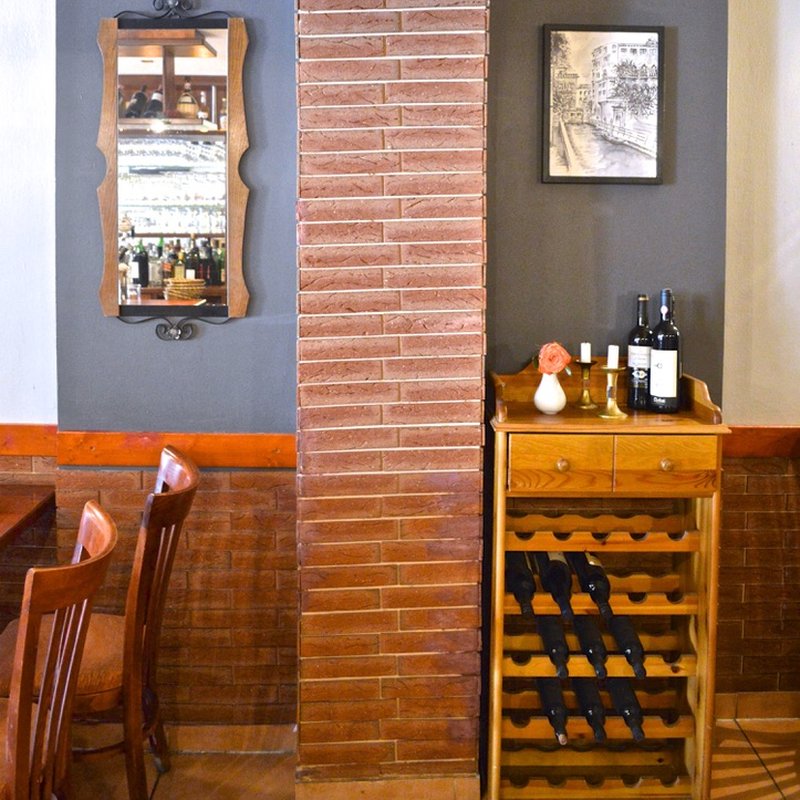 Speisekarte Weinregal und Ziegelsäule im Gastraum